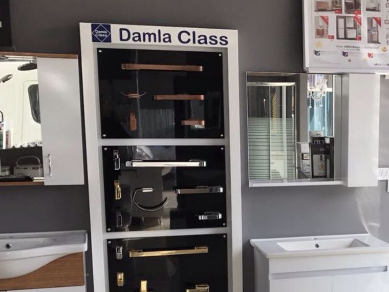 Aktekin Yapı showroomunda farklı renk ve yüzeylerde banyo aksesuarlarının sergilendiği pano